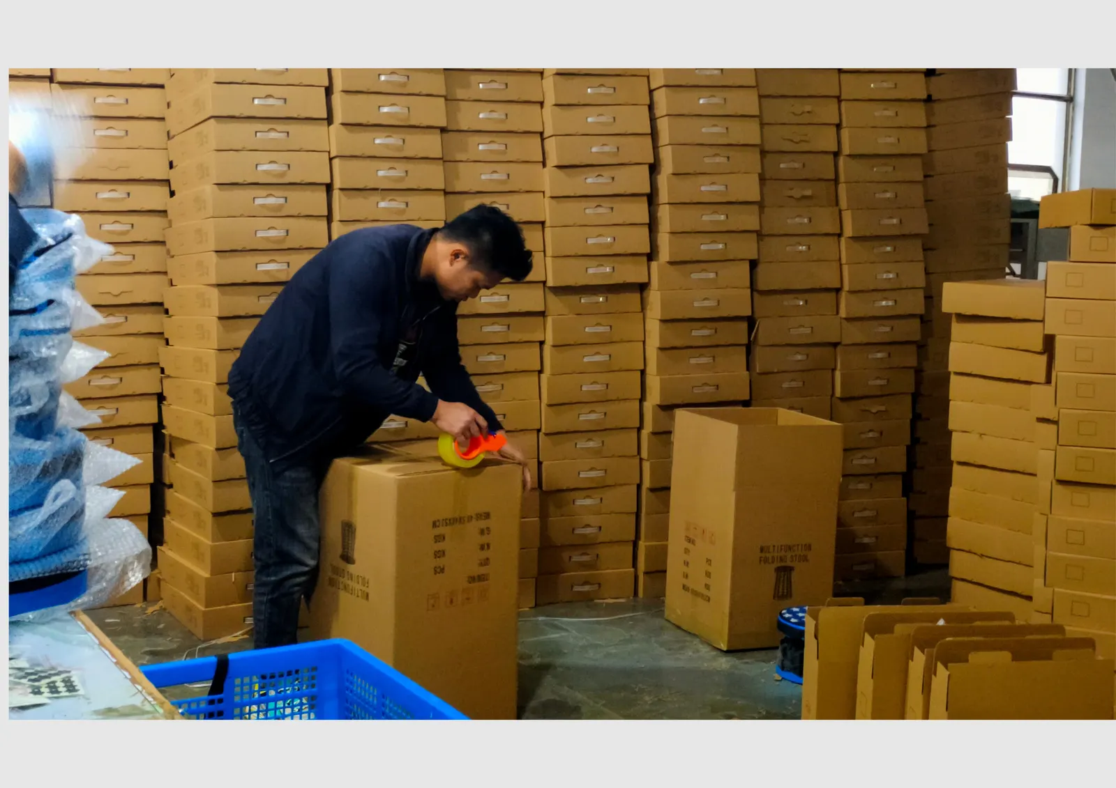Worker packing collapsible stool cartons in Locyop factory warehouse - Yiwu China wholesale manufacturer